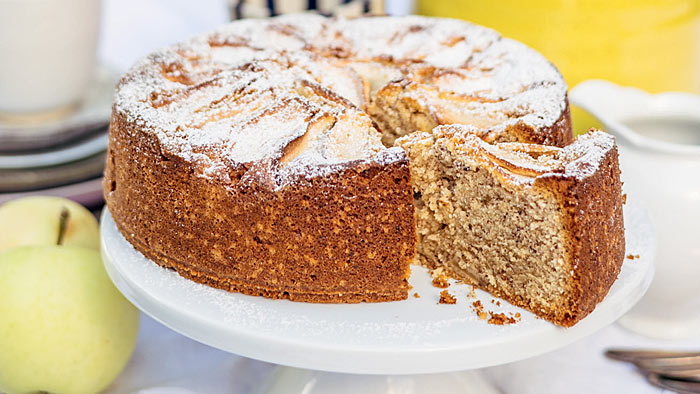 Rezept für Apfel-Haselnusskuchen Apfel-Haselnusskuchen auf weißer Kuchenplatte. | © Kathrin Salzwedel / Ramin Madani